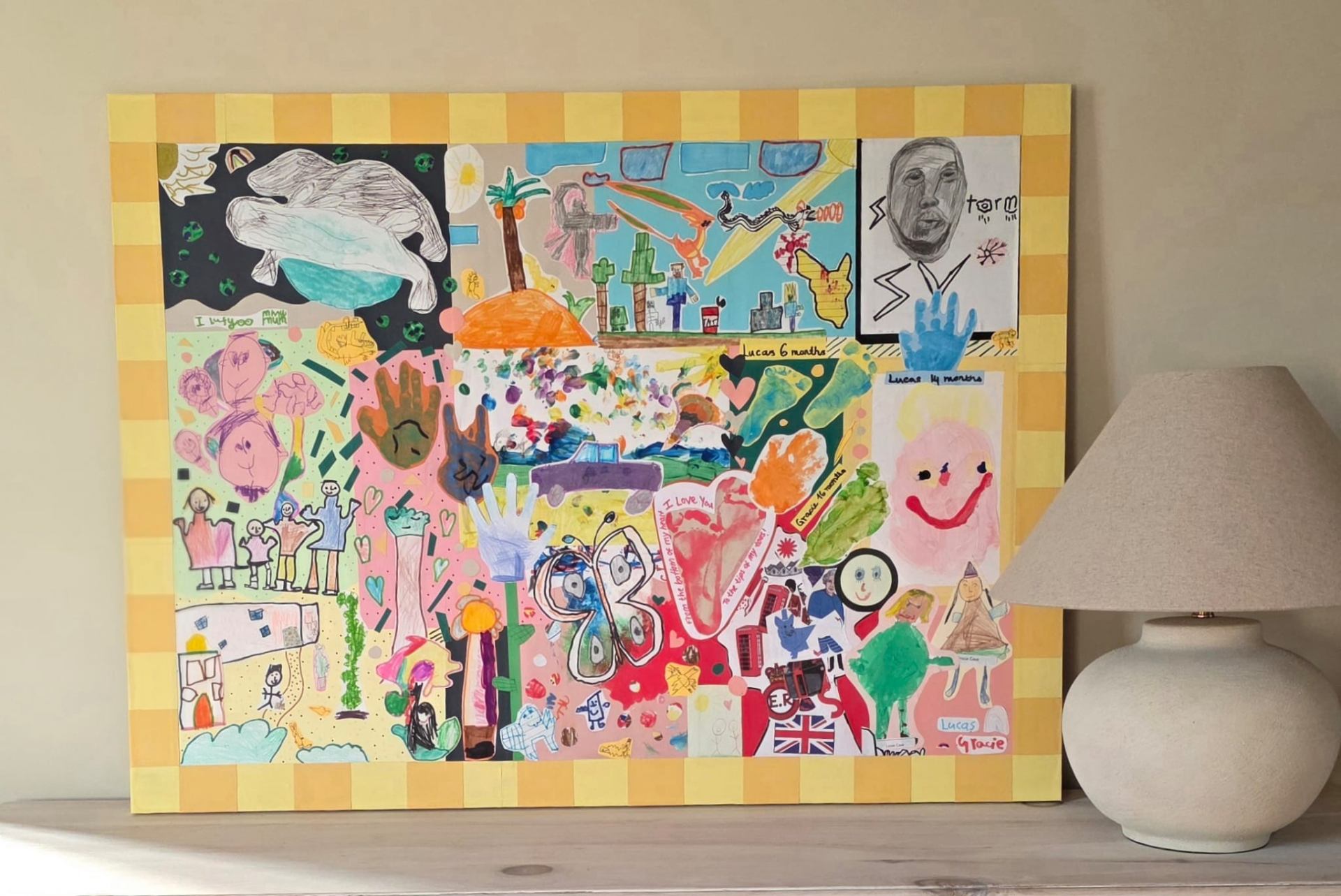 Finished bespoke children's art collage with checkered border displayed at home
